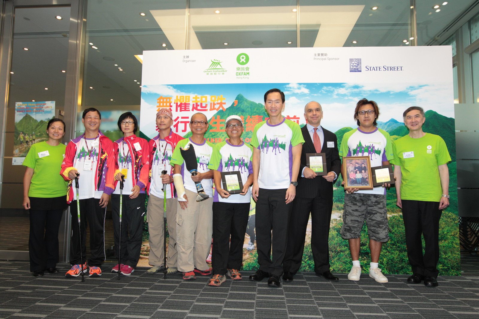 (From left to right) Kanie Siu (Director of Fundraising & Communications, Oxfam Hong Kong); Kim Mok (visually-impaired trailwalker); Alsa Kwok (visually-impaired trailwalker); Michael Ng (hearing-impaired trailwalker), amputee trailwalker Fung Kam Hung; Mrs Fung; Bernard Chan, Francesco M. Squillacioti from State Street; Tse Chi Kin; Stephen Fisher (Director General, Oxfam Hong Kong) gathered for a group photo.