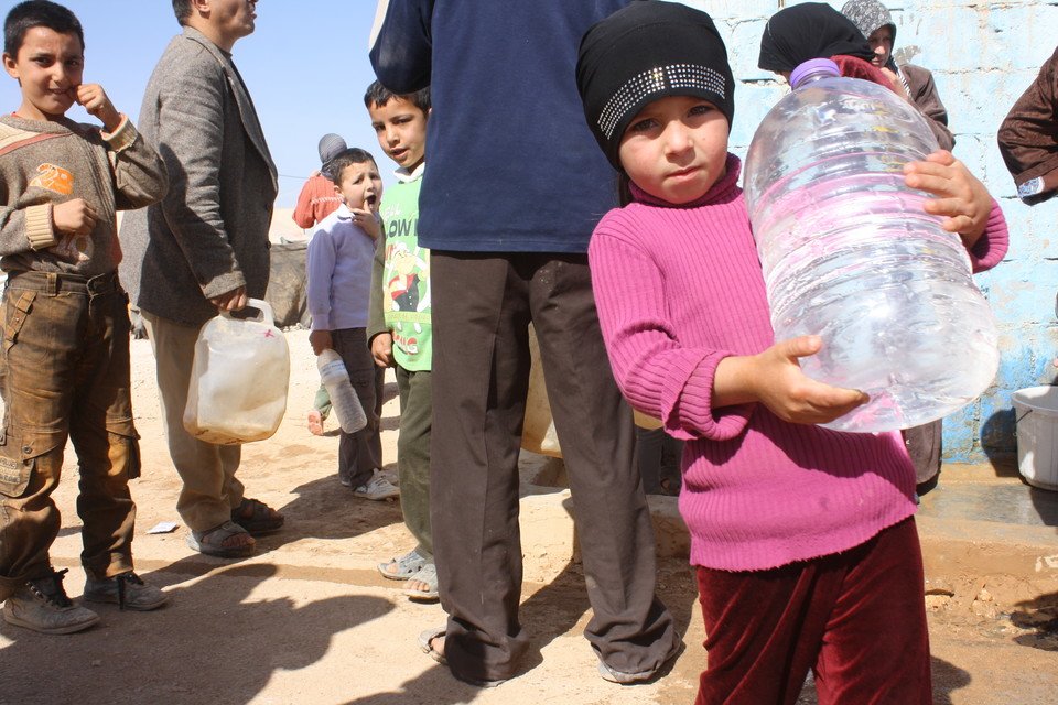 難民在約旦Zaatari難民營內拿取剛運到的食水