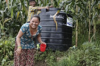 Sushila and Deepak collect clean water from an Oxfam tank. The tank supplies ten households in the village of Burunchili, where only 25 of its 200 houses were left standing. Oxfam supplied the village with clean water, toilets and hygiene kits. (Photo: Sam Tarling/Oxfam)