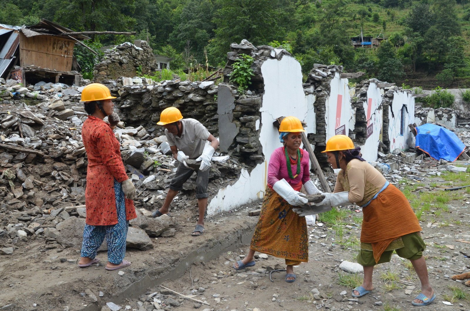 Dil Maya Sunar (pictured second from right) helped clear the debris from a collapsed school block. “We generally work on the farm but this time, the earthquake swept away our land where we would grow corn, and I’ve nothing else to do,” said Dil Maya. She worked for 15 days under Oxfam’s Cash for Work Programme. (Photo: Rakesh Tuladhar/Oxfam)