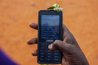 Mobile phone with text message about cash transfer.