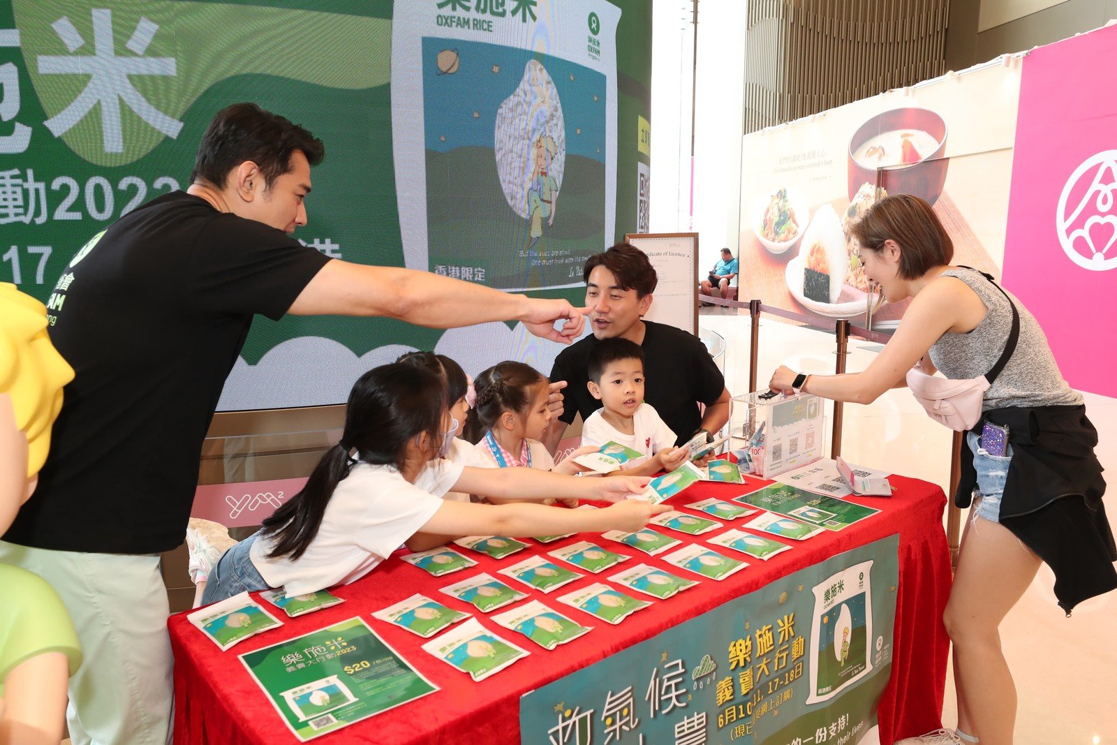 Artists Tony Hung (right 2) and Stefan Wong (left 1), and Stefan Wong’s daughter (left 2) and friends selling Oxfam Rice to support small farmers living in poverty.